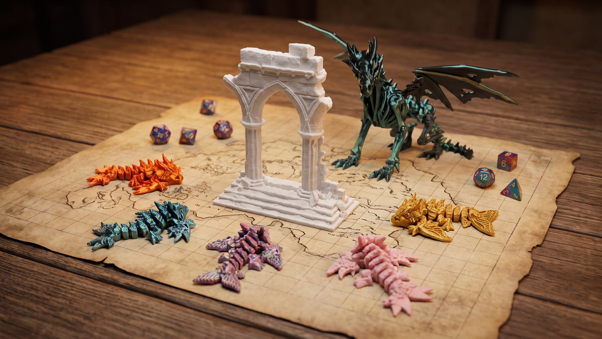 A role-playing game table with a parchment map, dice, a white 3D printed ruined gothic archway, five small articulated mini dragons and a black-green skeleton dragon posed as the boss